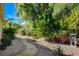 Mature landscaping and desert vegetation accent a gravel path, adding beauty to the backyard's tranquil outdoor space at 10302 Cara Mia Ct, Las Vegas, NV 89135