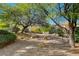 Tranquil backyard featuring mature trees, stone landscaping, and a patio set at 10302 Cara Mia Ct, Las Vegas, NV 89135