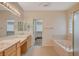 Well-lit primary bathroom featuring double sinks, a soaking tub, and a glass-enclosed shower at 10302 Cara Mia Ct, Las Vegas, NV 89135