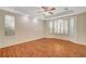 Sunlit bedroom with tray ceiling, wood floors and large bay windows with stylish white shutters at 10302 Cara Mia Ct, Las Vegas, NV 89135