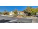 Single-story home with an attached garage boasts vibrant desert landscaping and convenient street access, showcasing its charm at 10302 Cara Mia Ct, Las Vegas, NV 89135