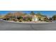 A single-story home is surrounded by mature desert landscaping with a circular driveway adding to its curb appeal at 10302 Cara Mia Ct, Las Vegas, NV 89135