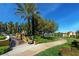 Exterior garden view featuring a patio, green lawns, mature trees, and manicured landscaping at 10302 Cara Mia Ct, Las Vegas, NV 89135
