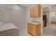 Bright laundry room features a sink, wooden cabinets, and convenient upper shelving for optimal storage and organization at 10302 Cara Mia Ct, Las Vegas, NV 89135