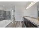 Luxurious bathroom with dual vanities, a soaking tub, granite countertops, and a glass-enclosed shower at 11088 Westcroft Way, Las Vegas, NV 89183