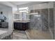 Modern bathroom featuring a glass shower, dual vanity with granite countertops, and grey wood-style flooring at 11088 Westcroft Way, Las Vegas, NV 89183