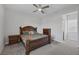 Cozy bedroom features a ceiling fan and an elegant, wood-framed bed with nightstands and a dresser at 11088 Westcroft Way, Las Vegas, NV 89183