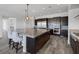 Spacious kitchen featuring dark cabinetry, stainless steel appliances, and a large granite island at 11088 Westcroft Way, Las Vegas, NV 89183