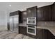 Close up view of the stainless steel refrigerator and double ovens, accented by a tile backsplash at 11088 Westcroft Way, Las Vegas, NV 89183