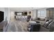 Open-concept living space with seating, dining area, and kitchen, all with modern finishes and wood floors at 11088 Westcroft Way, Las Vegas, NV 89183