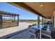 Covered patio with dining and lounge seating, views of the backyard, barbecue, and desert landscape at 11088 Westcroft Way, Las Vegas, NV 89183