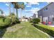 Lush backyard features green grass, mature palms, and patio with table and seating at 1680 Sweet Pea Ave, Las Vegas, NV 89183