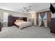 Spacious main bedroom with dark wood furnishings, ceiling fan and neutral colored carpet at 1680 Sweet Pea Ave, Las Vegas, NV 89183