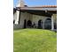 Exterior featuring arched windows, a covered patio, and a large grassy backyard at 2100 Plaza Del Padre, Las Vegas, NV 89102
