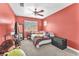 This bedroom features red walls, carpet flooring, a ceiling fan, a bed, and a large window at 2104 Spanish Town Ave, North Las Vegas, NV 89031