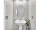 A lovely powder room featuring a pedestal sink, oval mirror, and soft, neutral wall color at 2104 Spanish Town Ave, North Las Vegas, NV 89031