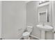 Powder room featuring a pedestal sink, mirror, and toilet at 2228 Sky Island Dr, Henderson, NV 89002
