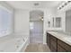 Bright bathroom featuring double sinks, granite countertops, a soaking tub, and a window at 2228 Sky Island Dr, Henderson, NV 89002