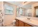 Well-lit bathroom with a tiled countertop, wooden cabinets, and a large mirror at 2325 Windmill Pkwy # 312, Henderson, NV 89074