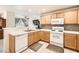 Bright kitchen featuring wooden cabinets, white appliances, and tiled backsplash at 2325 Windmill Pkwy # 312, Henderson, NV 89074