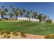 Rhodes Ranch community entrance with lush landscaping, palm trees, and a vibrant green lawn at 248 Windmill Croft Dr, Las Vegas, NV 89148