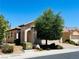 Single-story stucco home featuring desert landscaping, a barrel tile roof, and an arched entryway at 248 Windmill Croft Dr, Las Vegas, NV 89148