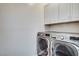 Convenient laundry room featuring a side-by-side washer and dryer and storage cabinets at 248 Windmill Croft Dr, Las Vegas, NV 89148