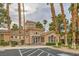 Stunning clubhouse entrance features a tile roof, tall palm trees, and ample parking at 251 S Green Valley Pkwy # 1311, Henderson, NV 89012