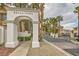 Community entrance featuring a white stone archway, well-manicured landscaping, and mature palm trees at 251 S Green Valley Pkwy # 1311, Henderson, NV 89012