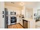 Modern kitchen with white cabinets, stainless steel appliances and a view of the living room at 251 S Green Valley Pkwy # 1311, Henderson, NV 89012