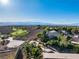 Elevated view of a community with lush greenery, a nearby golf course, and a panorama of distant mountains at 2612 Dearport Ct, Henderson, NV 89052