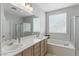 Bathroom featuring double sinks, a soaking tub, and a glass-enclosed shower at 2612 Dearport Ct, Henderson, NV 89052