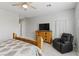 Bedroom features a wooden bed, dresser with television, and relaxing armchair at 2612 Dearport Ct, Henderson, NV 89052