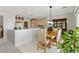 Open dining area with a modern light fixture and convenient breakfast bar seating at 2612 Dearport Ct, Henderson, NV 89052