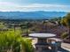 Inviting outdoor space with stone table, bench seating, and scenic views of the golf course and mountains at 2612 Dearport Ct, Henderson, NV 89052
