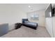 Cozy bedroom with neutral tones, a large window, and a mounted television for relaxed living at 2729 Pavehawk Way, Las Vegas, NV 89156