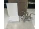 Sample materials showing modern bathroom faucet with matching bright quartz, white and grey tiling, and a neutral colored cabinet at 2775 Fantoni St, Henderson, NV 89044