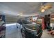 Spacious garage with car and workspace, featuring ceiling fan and roll-up door at 291 E Hickory St, Pahrump, NV 89048