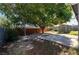 Shaded backyard featuring mature trees, a concrete patio, a shed, and a privacy fence at 321 Princess Ave, North Las Vegas, NV 89030