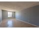 Open-plan living room with laminate floors, light grey walls, and a window at 321 Princess Ave, North Las Vegas, NV 89030