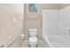 Bright bathroom featuring neutral walls, a shower-tub, toilet, safety bars, and a small window for natural light at 3521 Discovery Downs Ct, North Las Vegas, NV 89081
