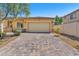 Charming single-story home featuring a spacious two-car garage and a brick-paved driveway at 3521 Discovery Downs Ct, North Las Vegas, NV 89081