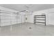 Spacious garage featuring sealed concrete floor, storage rack, and garage door at 3521 Discovery Downs Ct, North Las Vegas, NV 89081