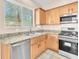 Bright kitchen featuring stainless appliances, granite counters, wood cabinetry and a window view at 3521 Discovery Downs Ct, North Las Vegas, NV 89081