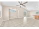 Spacious living room with neutral walls, tile flooring, ceiling fan, and lots of natural light at 3521 Discovery Downs Ct, North Las Vegas, NV 89081