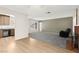 Open living room featuring a brick fireplace, neutral colors, and hardwood floors with gray carpet at 421 Carlin Ave, Las Vegas, NV 89110