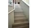 Carpeted staircase with white railings and neutral paint; artwork on the wall at 4363 Pittsfield St, Las Vegas, NV 89115