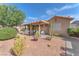 A view of the back of the home from the yard, with a covered patio and desert landscaping at 452 Waterwheel Falls Dr, Henderson, NV 89015