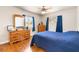 Bedroom featuring hardwood floors, wooden dresser, ceiling fan, and a comfortable bed with blue comforter at 5449 Desert Spring Rd, Las Vegas, NV 89149