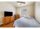 Bedroom with wooden floors and ceiling fan, featuring a comfortable bed and matching wooden dressers at 5449 Desert Spring Rd, Las Vegas, NV 89149